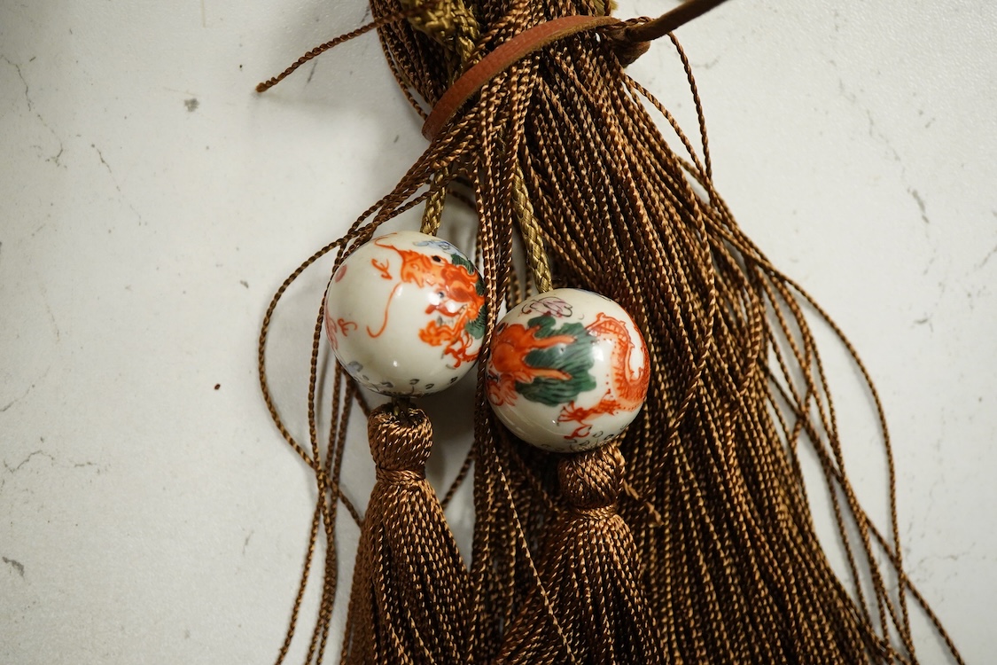 A Chinese carved hardwood Ruyi sceptre, with two porcelain ‘dragon’ beads, 50cm in length
